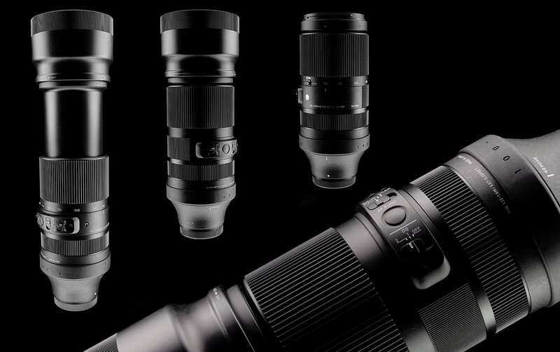 Collection of vintage telephoto lenses arranged on black background with one large lens in foreground.