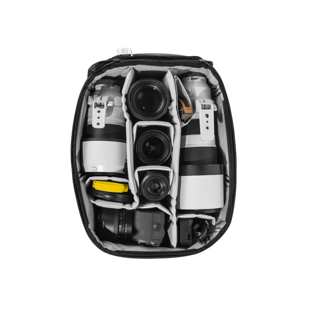 Overhead view of an open camera backpack with organized compartments holding three cameras and accessories.