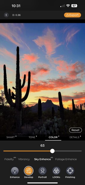 Saguaro cactus silhouetted against a vibrant sunset sky with pink and orange clouds.