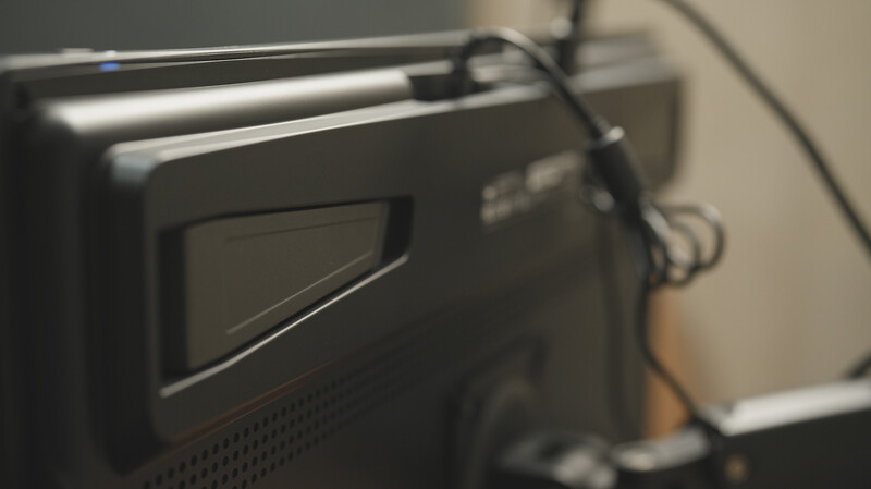 Close-up of a professional video monitor or field recorder with a dark bezel and visible display screen.