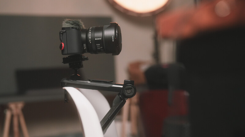Professional camera mounted on a ball head tripod with softbox diffuser positioned in a studio setting.