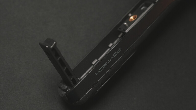 Black camera monitor or recorder with articulating arm mounted on dark surface.