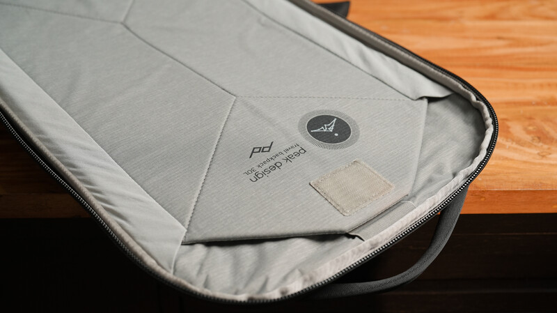 Interior view of a padded camera bag with gray fabric and white protective lining.
