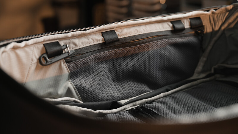 Interior view of an open camera bag with black padded dividers and cream-colored lining.