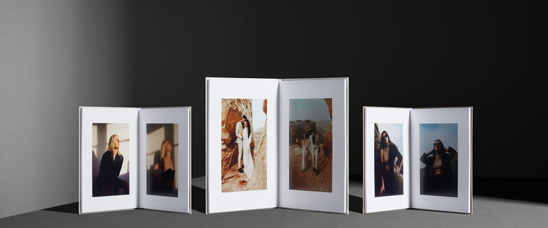 Three open white photo frames displaying portrait and landscape photographs arranged in a row against a neutral gray background.