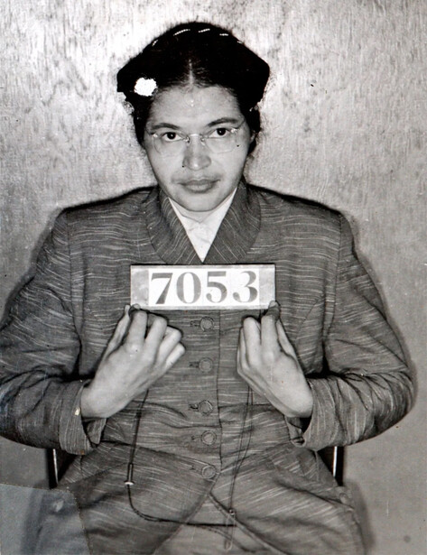 Black and white mugshot of a woman holding a numbered placard, head-on pose against plain background.