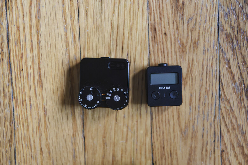 Two black camera flash triggers displayed side-by-side on wooden surface.