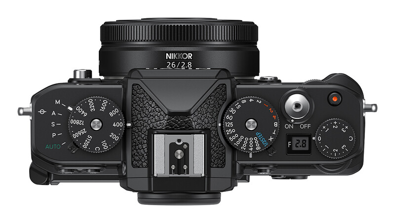 Top-down view of a Nikon mirrorless camera with a 26/2.8 lens attached, showing dual control dials and manual exposure settings.