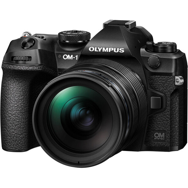 Olympus OM-1 mirrorless camera with attached zoom lens on white background.