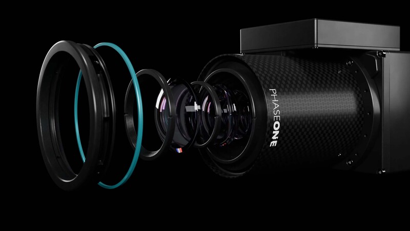 Exploded view illustration of a camera lens showing internal optical elements and mechanical components.