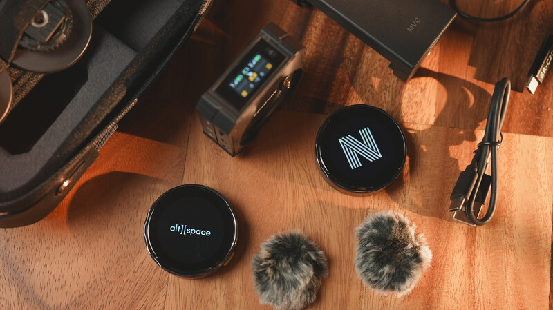 Overhead shot of audio equipment and microphone accessories arranged on a wooden surface.
