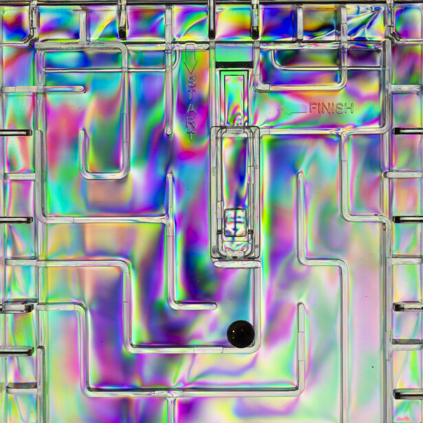 Abstract 3D maze structure with iridescent holographic gradient colors shifting through pink, purple, cyan, and green.