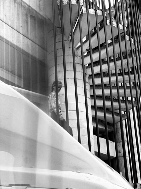 Geometric black and white photograph of modern building facade with angular lines and grid pattern windows.