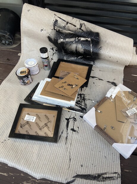 Disassembled camera and lens components laid out on white paper for cleaning and maintenance.
