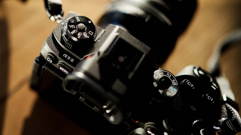 Close-up of professional video camera controls with mode dial and menu buttons in sharp focus.