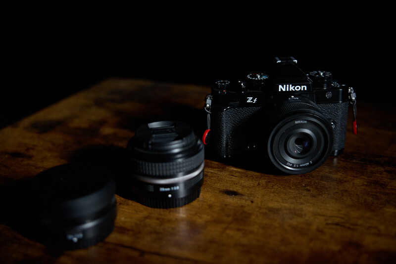 Nikon Z7 mirrorless camera with interchangeable lenses arranged on a wooden surface.