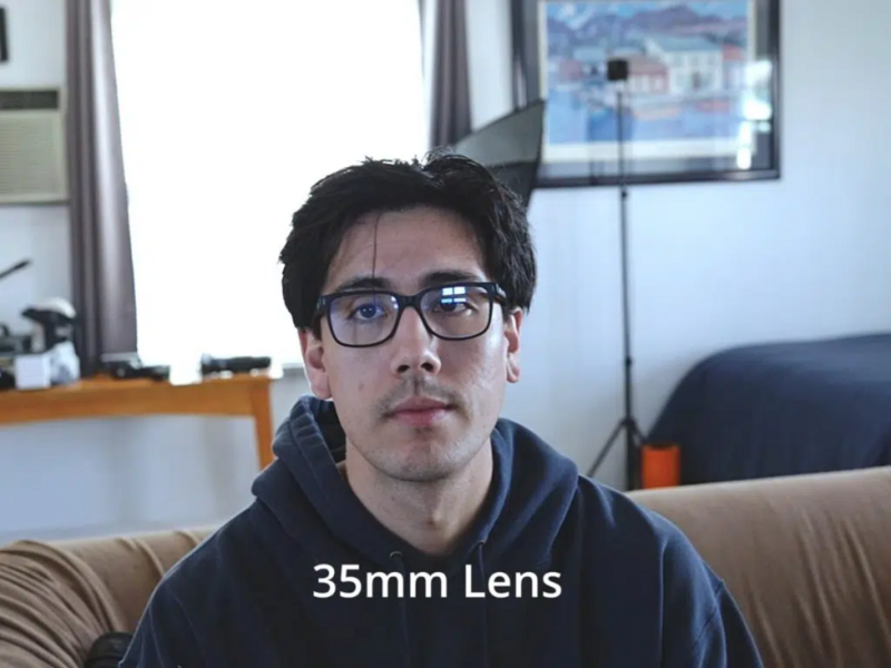 Man wearing glasses indoors with text overlay reading '35mm Lens.'