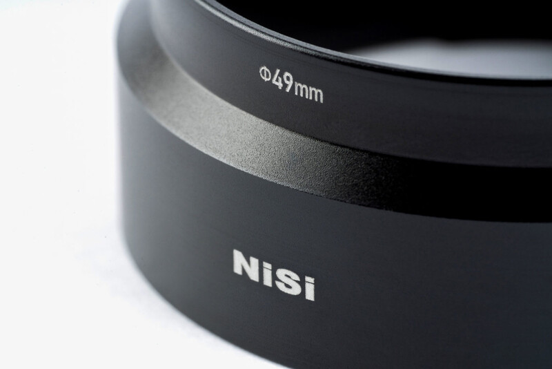 Close-up of a Nisi lens filter adapter ring marked Ø49mm with layered metal construction.