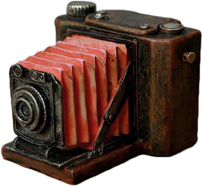 Vintage folding camera with red bellows and wooden body, shown from the side with lens extended.