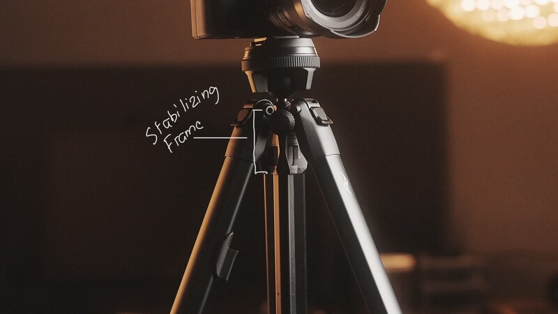 Camera mounted on tripod with stabilizing frame labeled during golden hour setup.