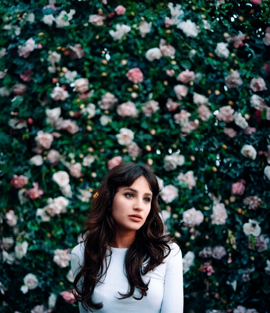 Model in front of a wall of flowers