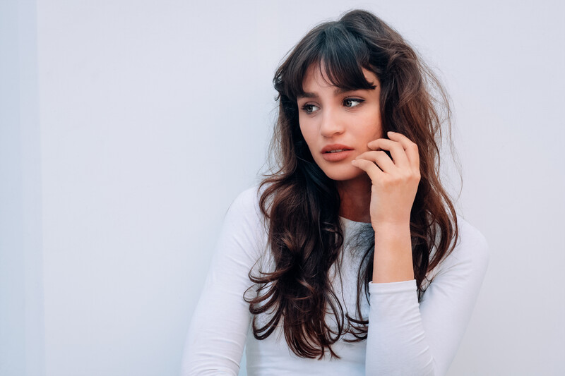 Model posing in front of a white wall.