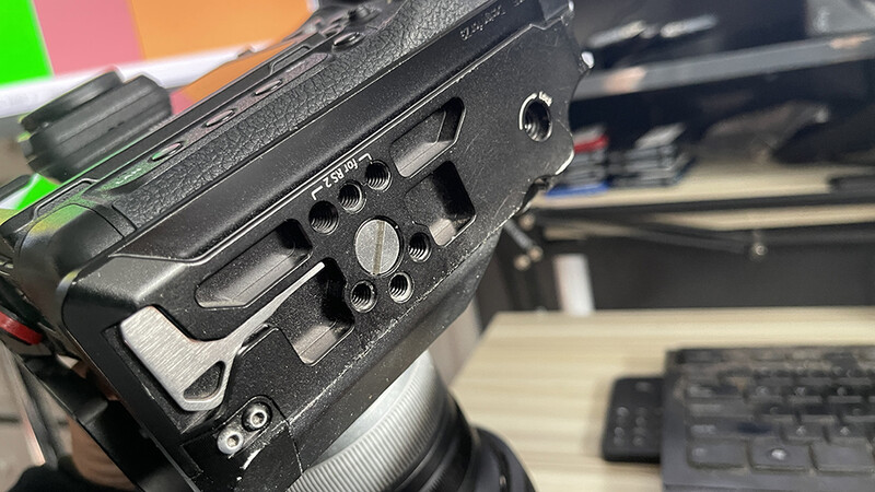 Close-up of a camera lens side panel with manual control dials and adjustment knobs.