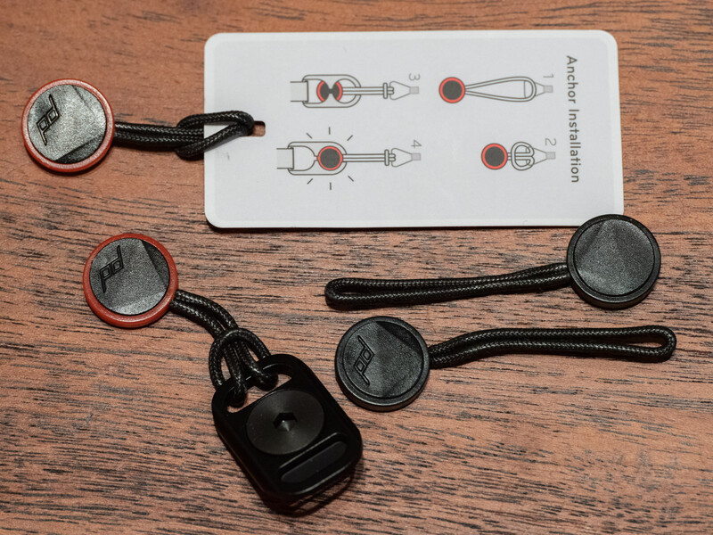 Photography lighting modifier kit with instruction card and cable releases on wooden surface.