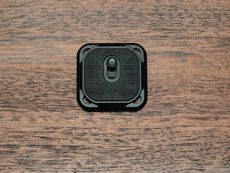 Dual-lens camera module mounted on weathered wood surface with textured pattern.