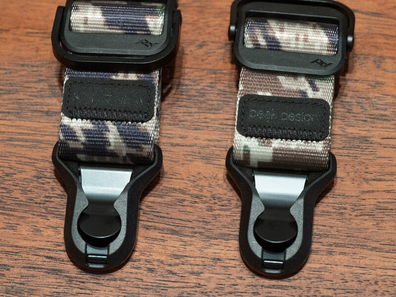 Two camera flash diffusers with white fabric covers and black plastic clips displayed on a wooden surface.