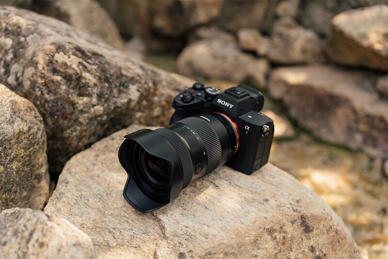 Sony mirrorless camera with wide-angle lens mounted, positioned on a textured rock surface.