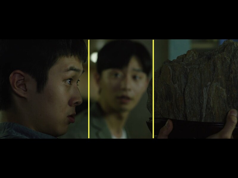 Screenshot of a film scene with two characters separated by vertical yellow lines, showing profile and frontal views with dark, moody lighting.