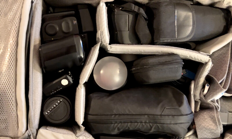 Photography equipment organized in a padded carrying case with foam compartments and protective dividers.