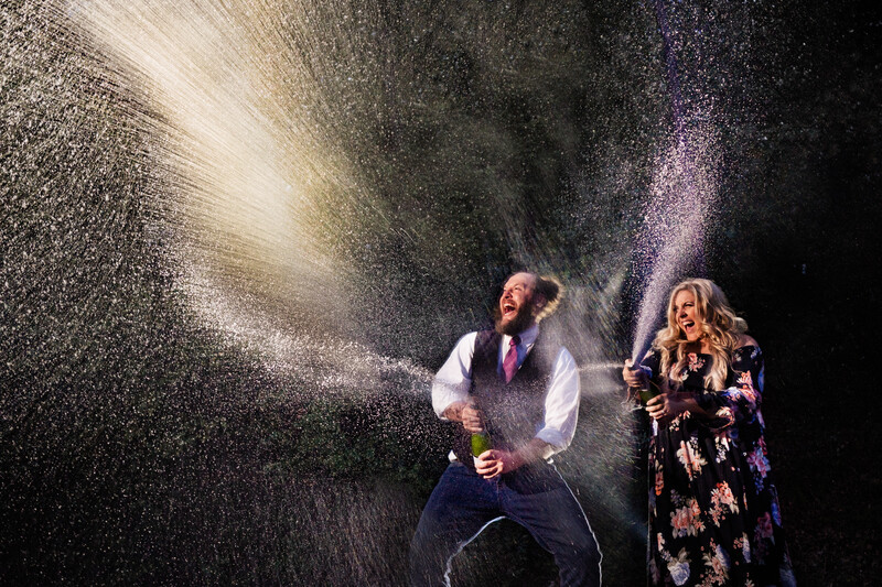 Man in vest and woman in floral dress performing on stage with dramatic powder explosions creating billowing clouds of white and colored particles.