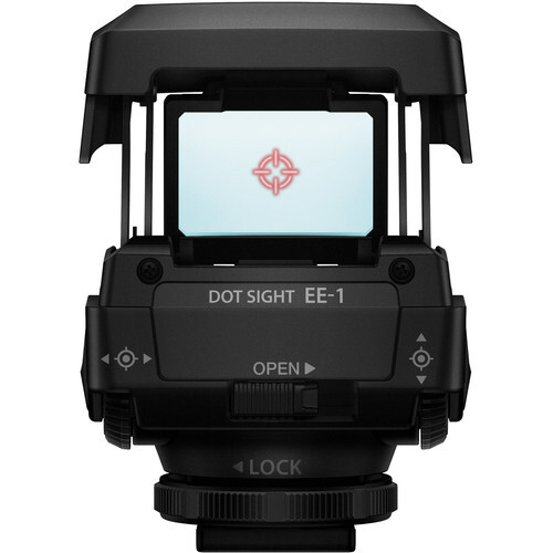 Top-down view of an electronic dot sight mounted on a camera hot shoe, displaying a illuminated reticle on its screen.