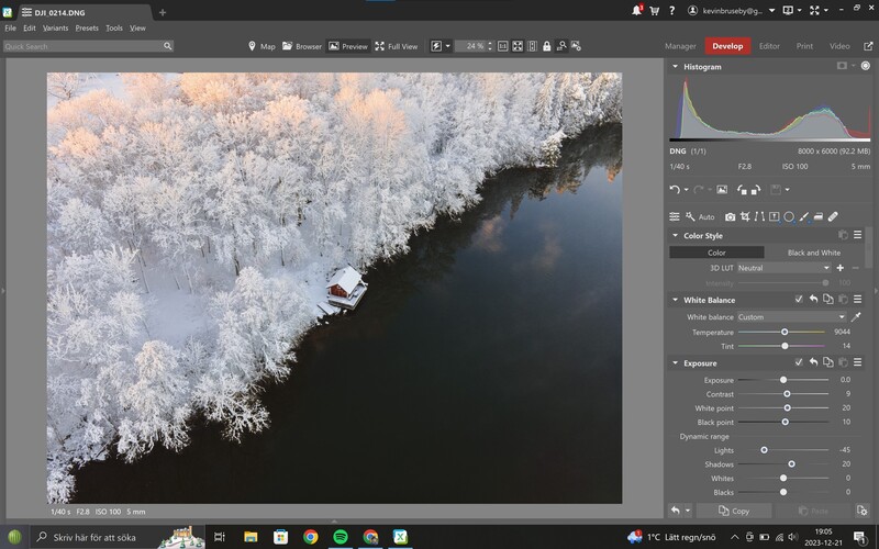 Screenshot of photo editing software showing a winter landscape with frost-covered trees along a dark river.