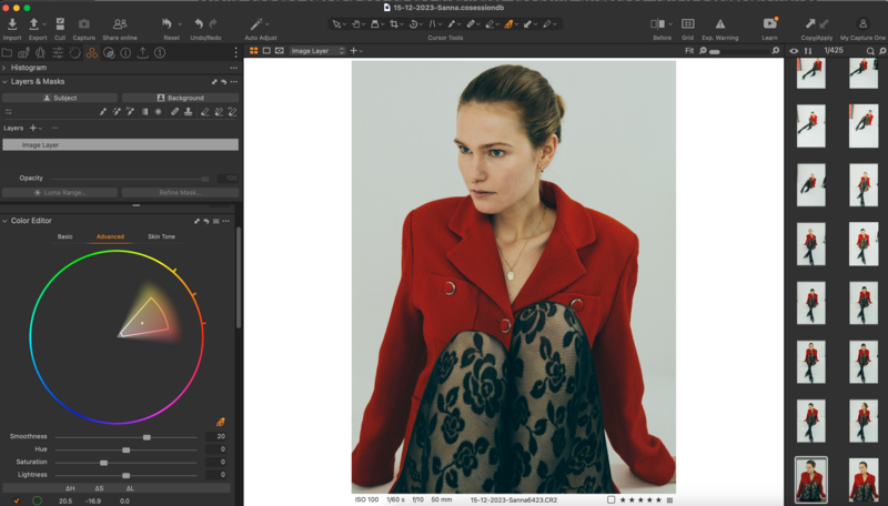 Woman wearing red blazer over patterned blue garment, photographed against neutral background.