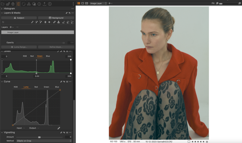 Woman wearing red blazer and patterned pants against neutral background.