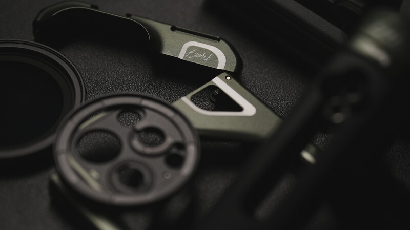 Close-up of camera controls including a shutter button and mode dial with textured black rubber and silver metal accents.