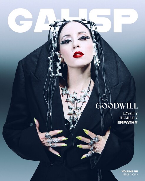 Portrait of a person with dramatic makeup and ornate black headpiece adorned with chains and accessories.