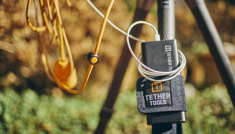Tether Tools gear organizer attached to camera support pole with coiled cables nearby.