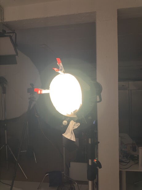 Powerful LED film light mounted on stand with barn doors and diffusion in studio setting.