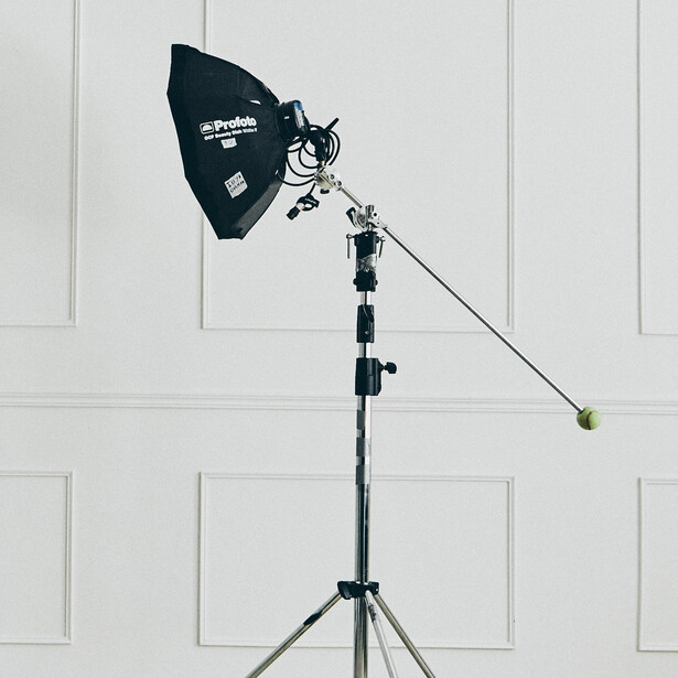 Softbox studio light mounted on tripod stand against white backdrop.