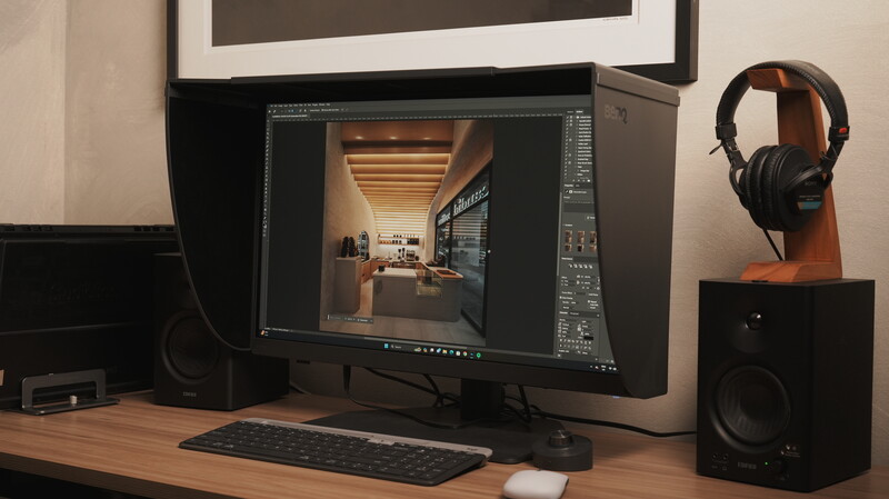 Professional workspace with monitor displaying architectural visualization in editing software.