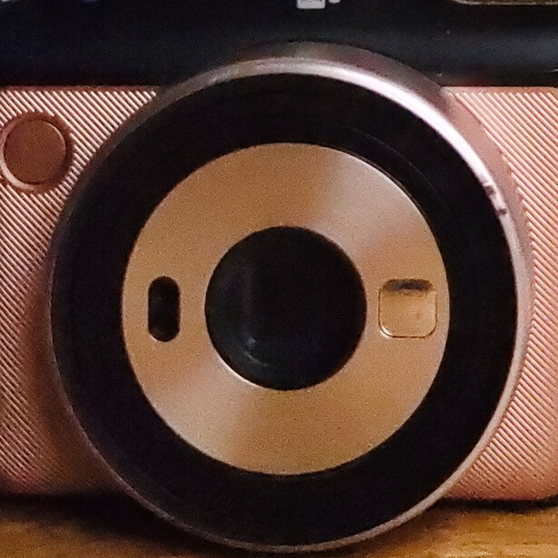 Fisheye lens view of a vintage film camera with tan and black exterior.