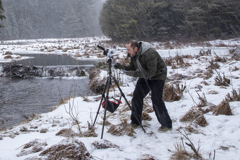 Photographer working in the snow near a lake