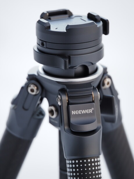 Neewer tripod head with ball mount and friction arms mounted on carbon fiber legs.