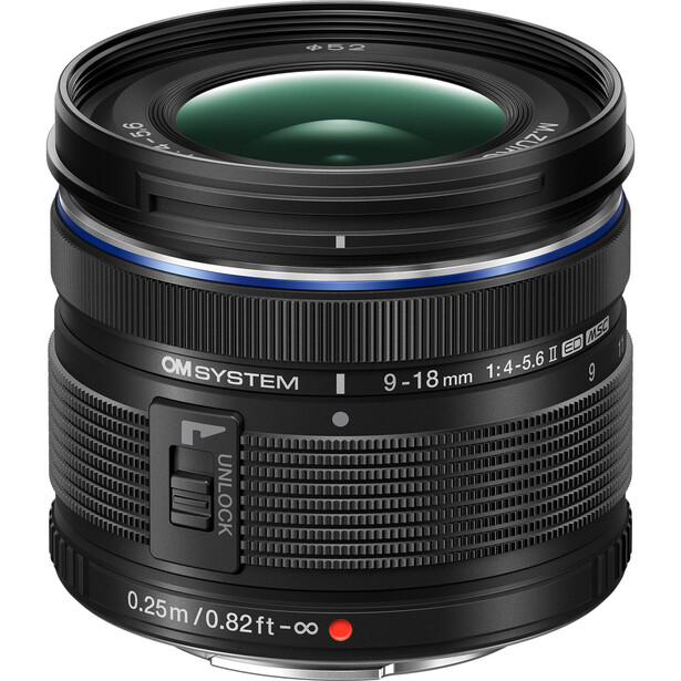 OM System 9-18mm f/4.5-5.6 ED wide-angle zoom lens with green glass element visible.