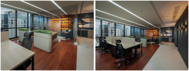 Modern open-plan office space with wooden flooring, white desks, black ergonomic chairs, and floor-to-ceiling windows overlooking a city skyline.