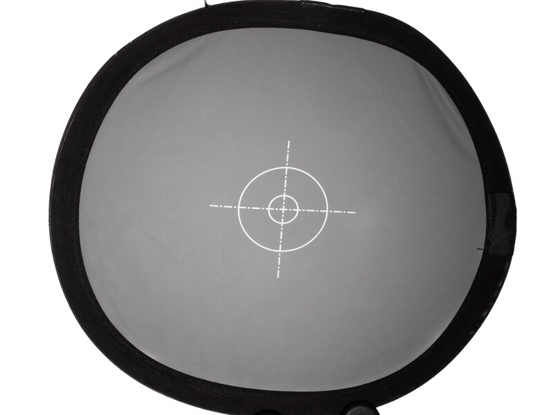 Gray calibration target with crosshair reticle and concentric circles for precise focus and exposure metering.